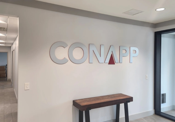 Con App logo mounted on the wall of an entryway.
